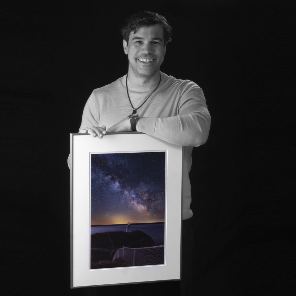 Andre Poirier holding artwork