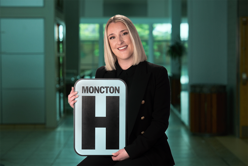 Marie-Pierre Robichaud Holding H Sign and Smiling at camera