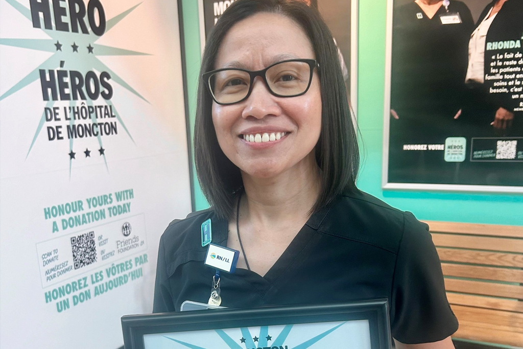 Rose Ehimplar Gizza, RN holding a hospital hero plaque