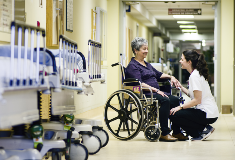 Lady in wheelchair with Caregiver smiling